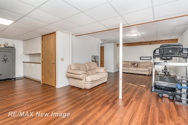 workout area with a drop ceiling and wood finished floors