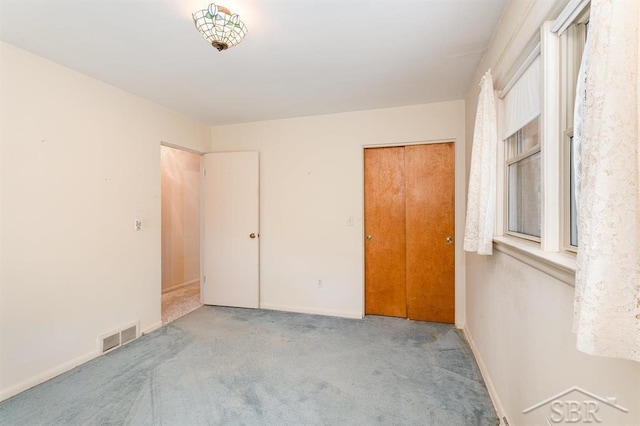 unfurnished bedroom featuring visible vents, carpet flooring, and baseboards
