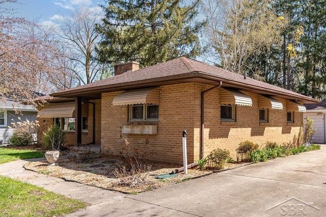 view of side of home featuring brick siding and a chimney