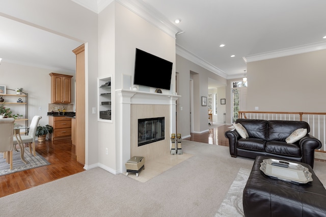 living area with carpet floors, crown molding, wood finished floors, a fireplace, and recessed lighting