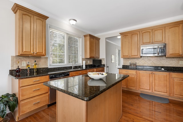 kitchen featuring a sink, appliances with stainless steel finishes, backsplash, and wood finished floors