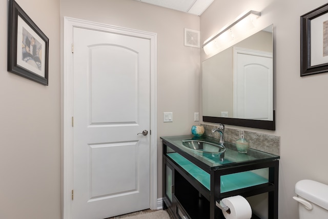 bathroom featuring visible vents, toilet, and vanity