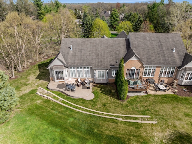back of property featuring a lawn, an outdoor living space, and a patio area