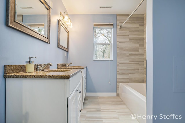 1355 Middle Ln, Battle Creek, MI 49014 - bathroom featuring double vanity, tub / shower combination, and electric panel