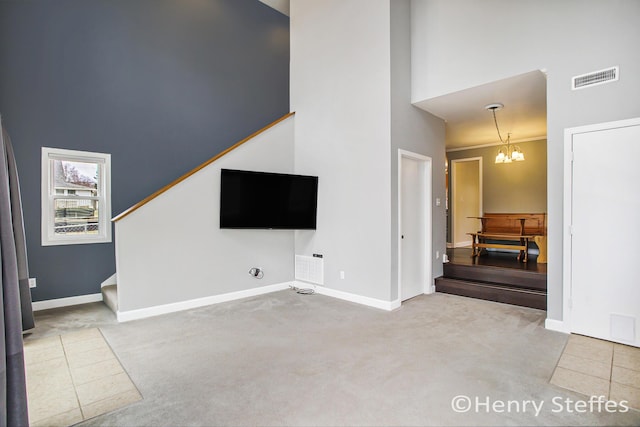 1355 Middle Ln, Battle Creek, MI 49014 - unfurnished living room with a high ceiling, carpet floors, stairway, and a chandelier
