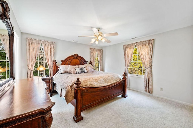 carpeted bedroom with baseboards, multiple windows, ceiling fan, and visible vents
