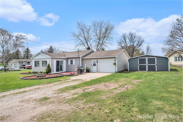 ranch-style home with an outdoor structure, driveway, a front yard, an attached garage, and a storage shed