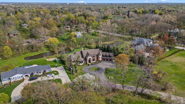 drone / aerial view featuring a water view and a wooded view