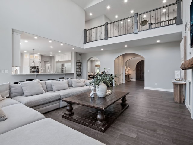 living room with recessed lighting, arched walkways, and a high ceiling