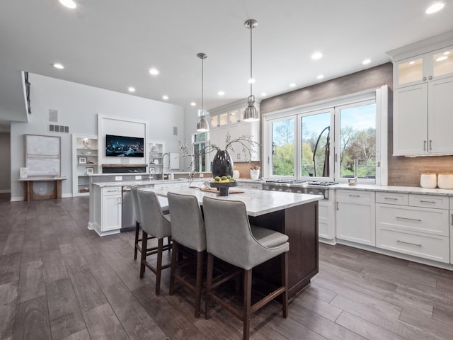 kitchen featuring decorative backsplash, dark wood-style flooring, a kitchen island, glass insert cabinets, and white cabinets