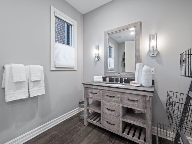 bathroom with baseboards, wood finished floors, and vanity