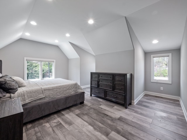bedroom with visible vents, light wood-type flooring, baseboards, lofted ceiling, and recessed lighting