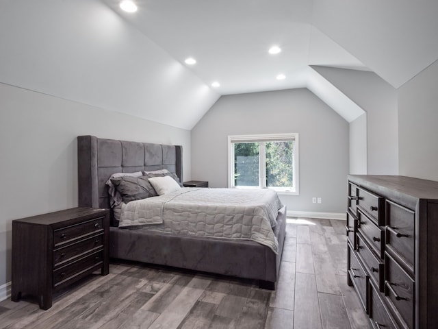 bedroom featuring baseboards, vaulted ceiling, recessed lighting, and wood finished floors