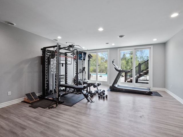workout room with recessed lighting, baseboards, and wood finished floors
