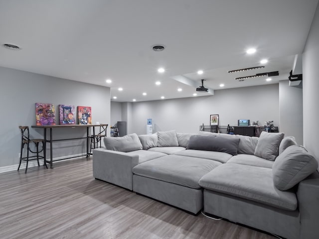 living area with recessed lighting, visible vents, and wood finished floors