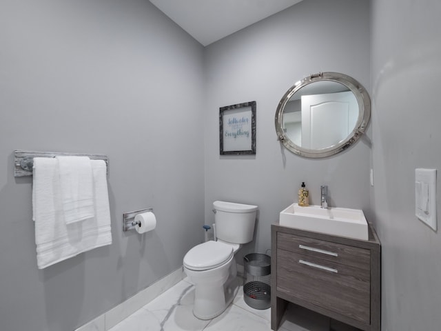 bathroom featuring vanity, baseboards, toilet, and marble finish floor