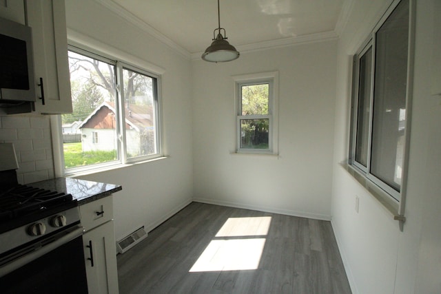 1068 La Salle Ave, Waterford, MI 48328 - unfurnished dining area with dark wood-style flooring, ornamental molding, baseboards, and visible vents