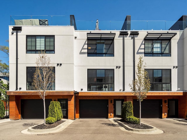 view of front of property featuring a garage, stucco siding, and driveway