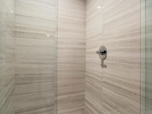 interior details featuring a tile shower