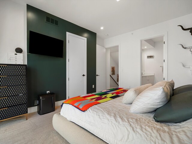 bedroom featuring recessed lighting, light colored carpet, ensuite bath, and visible vents