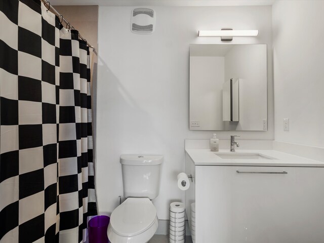 full bath featuring vanity, toilet, and curtained shower