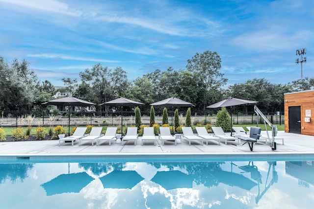 pool featuring fence and a patio