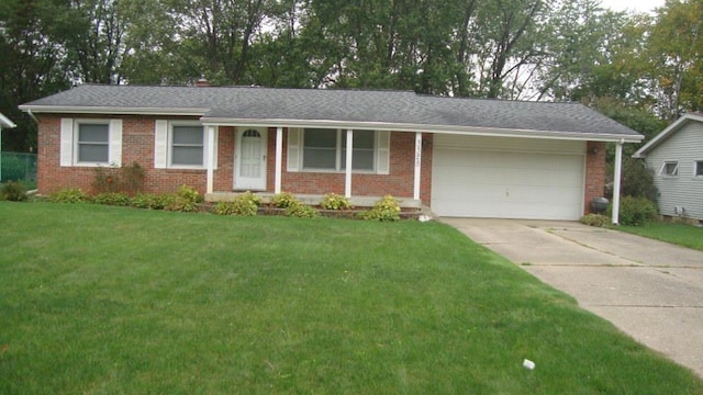 ranch-style house featuring an attached garage, driveway, a front yard, and brick siding