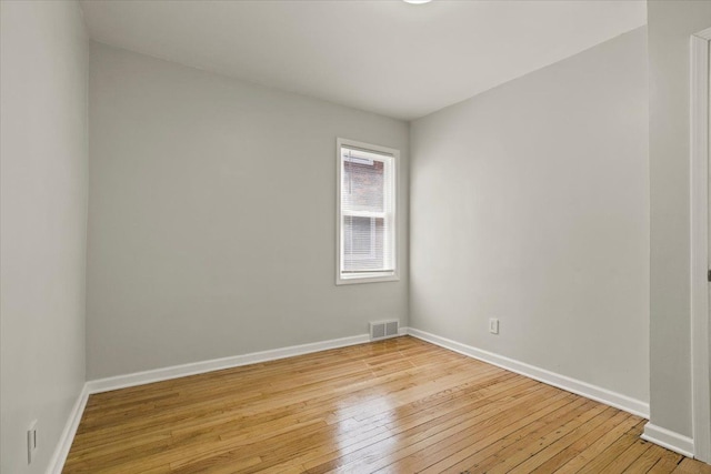 unfurnished room featuring baseboards, visible vents, and light wood-style floors