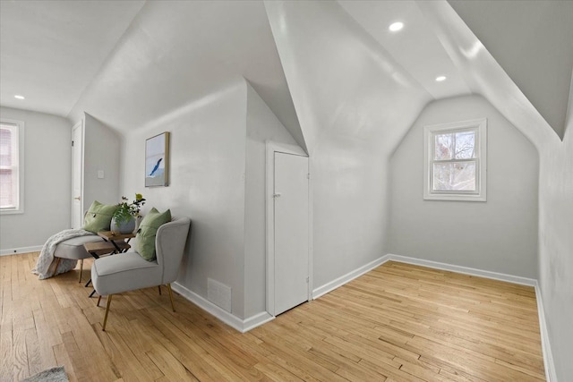 additional living space with visible vents, baseboards, light wood finished floors, and lofted ceiling