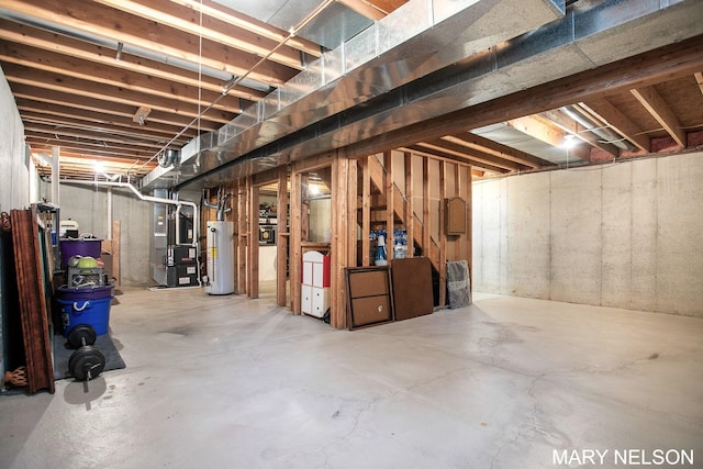 unfinished below grade area featuring heating unit and water heater