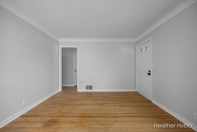 empty room with baseboards, light wood-style flooring, and visible vents