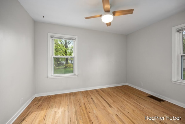 unfurnished room with light wood-type flooring, baseboards, a wealth of natural light, and visible vents