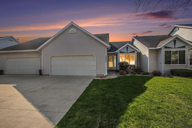 ranch-style house featuring an attached garage, driveway, and a front yard