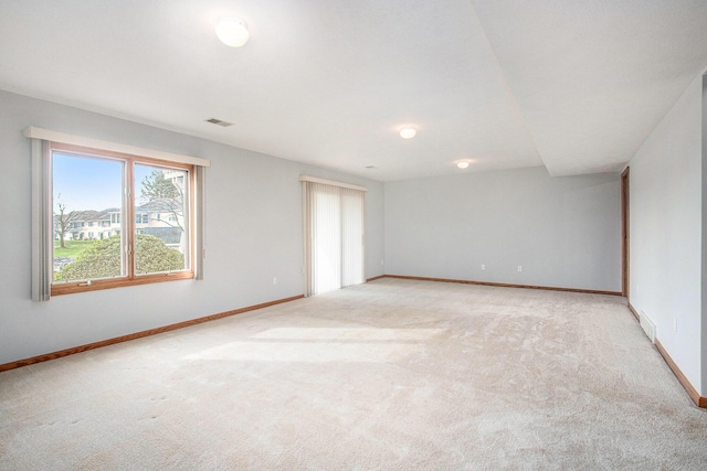 unfurnished room with baseboards, light carpet, and visible vents
