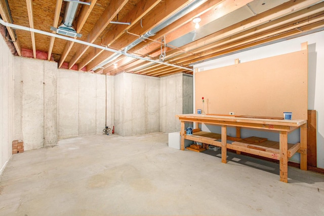 unfinished basement featuring a workshop area