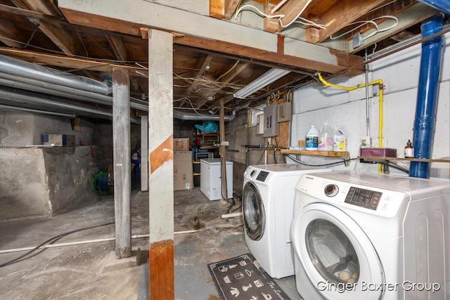 unfinished below grade area featuring electric panel and washing machine and dryer