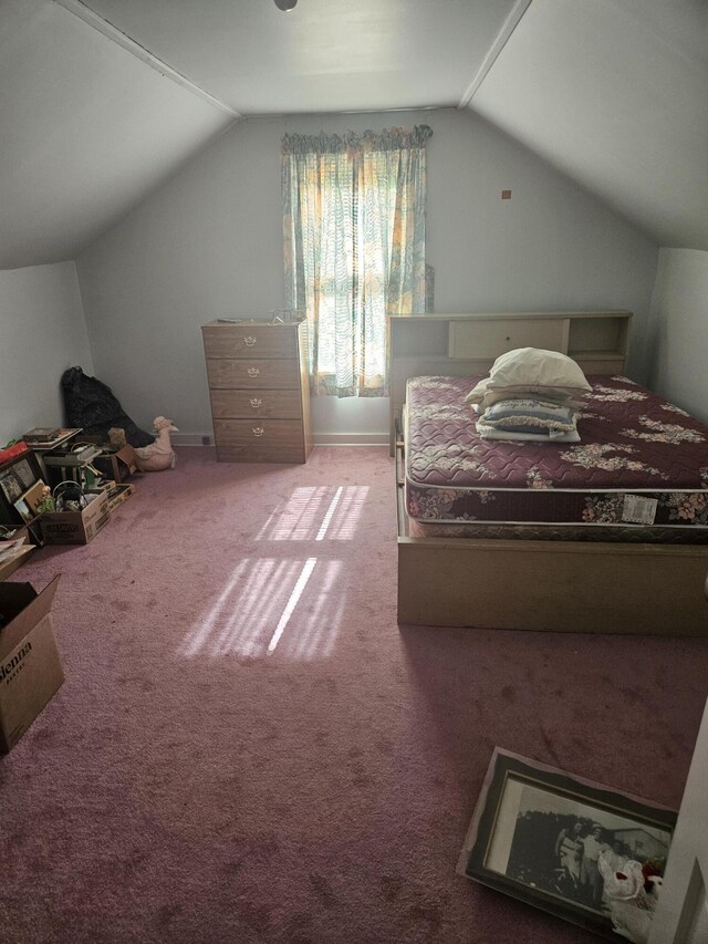 carpeted bedroom featuring baseboards and lofted ceiling