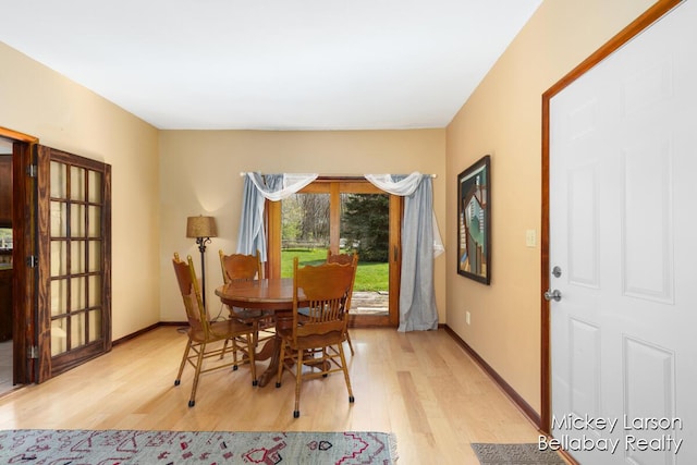 dining area featuring baseboards and light wood-style flooring