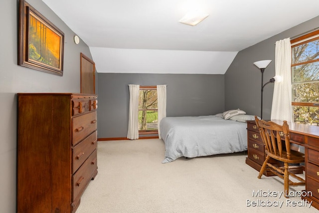 bedroom featuring baseboards, vaulted ceiling, light carpet, and multiple windows