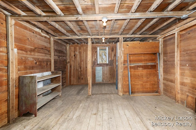 basement with wooden walls and hardwood / wood-style flooring