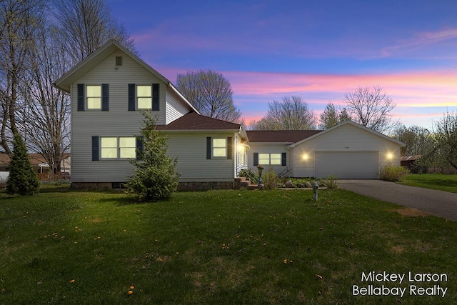traditional home featuring a garage, driveway, and a front lawn