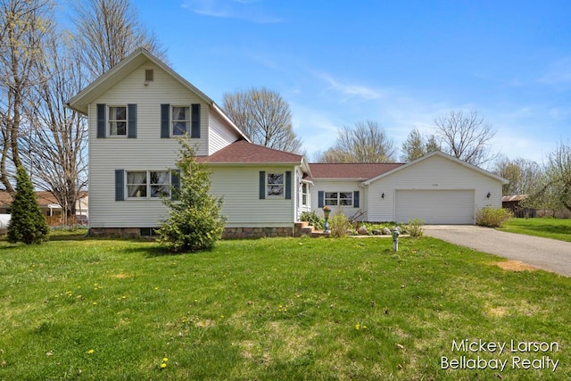 traditional-style house with a shingled roof, an attached garage, driveway, and a front yard