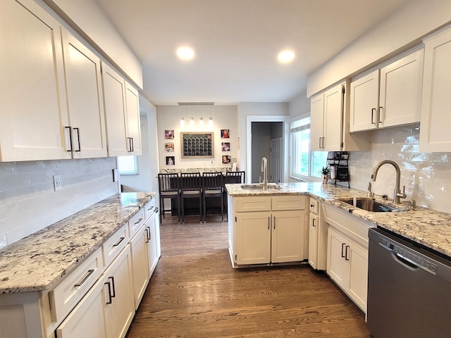 kitchen with a sink, backsplash, a peninsula, and dishwasher
