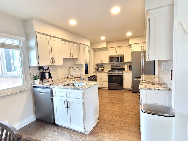 kitchen featuring stainless steel appliances, recessed lighting, a sink, and light wood finished floors