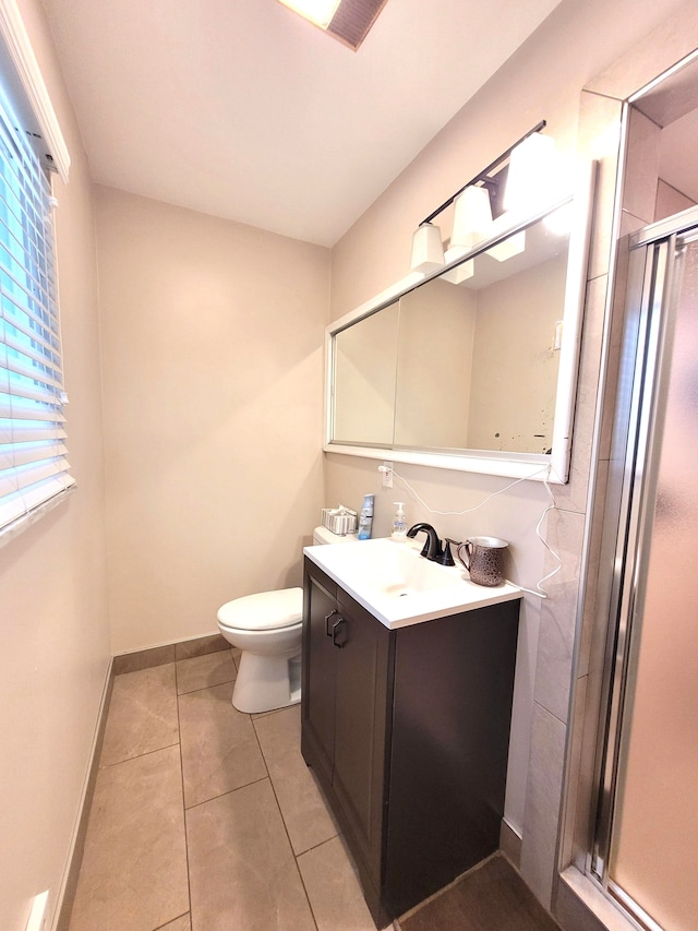 full bathroom featuring a shower stall, vanity, tile patterned floors, baseboards, and toilet
