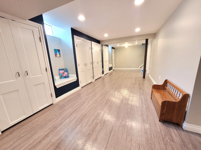 hall with baseboards, recessed lighting, and light wood-style floors