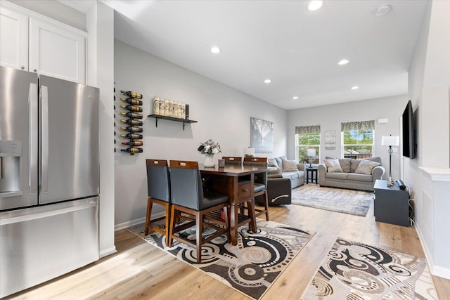 dining room featuring light wood-type flooring, recessed lighting, and baseboards