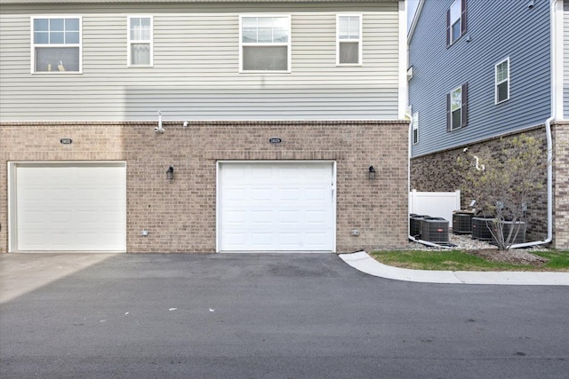 exterior space with an attached garage, driveway, and brick siding