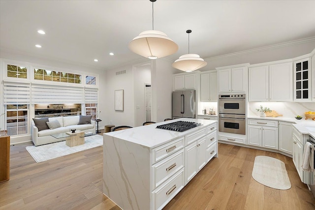 kitchen featuring light wood finished floors, stainless steel appliances, recessed lighting, ornamental molding, and glass insert cabinets