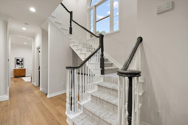 stairs with baseboards, recessed lighting, and wood finished floors